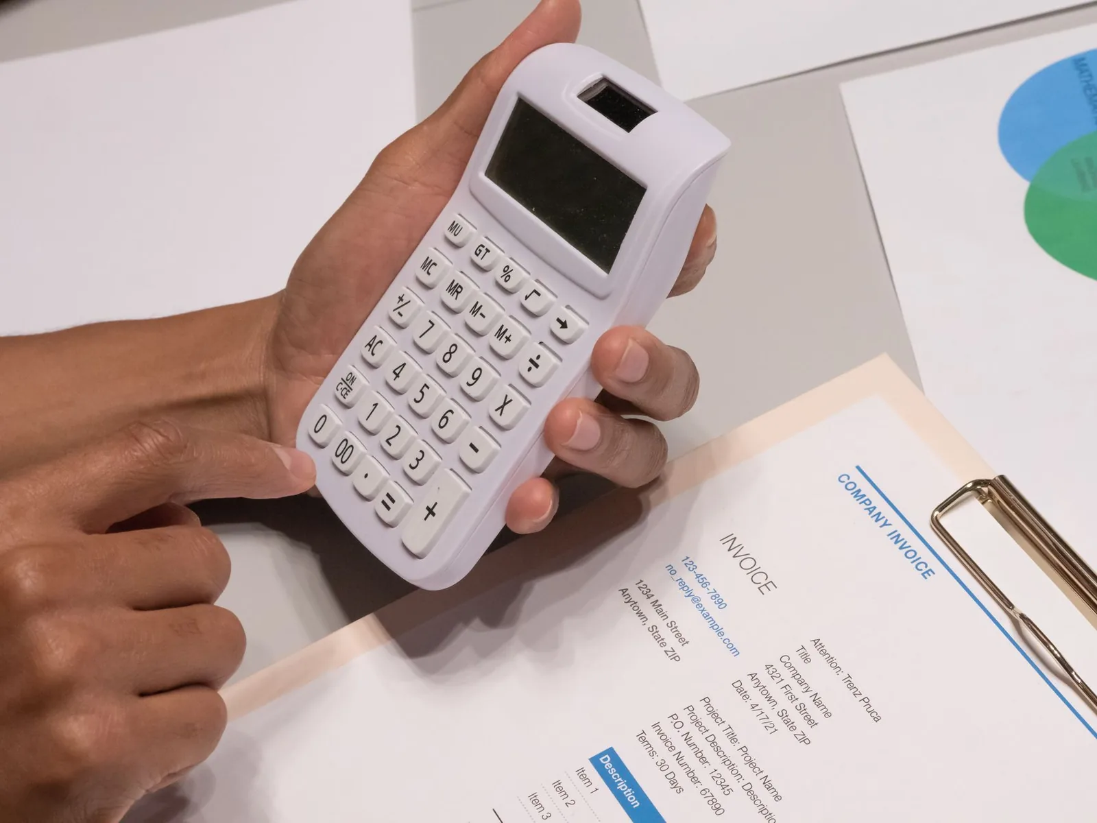 Nota fiscal impressa com código de barras sobre a mesa ao lado de uma calculadora
